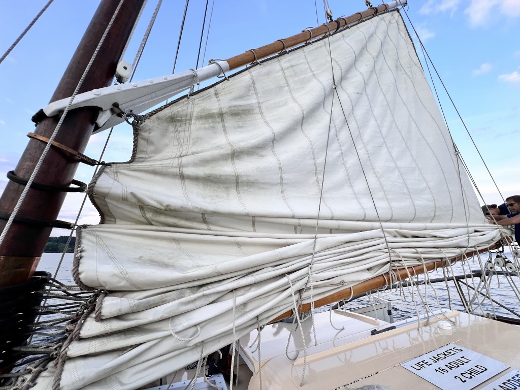 The Schooner Charm's sails being lowered